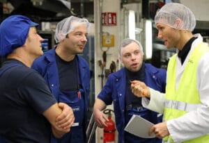 Dr. Utz Niklas Walter berät Mitarbeiter einer Produktion direkt am Arbeitsplatz.